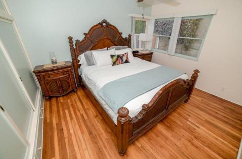 um quarto com uma cama de madeira e um piso de madeira em BEACHFRONT COTTAGE UPPER UNIT em Oceanside