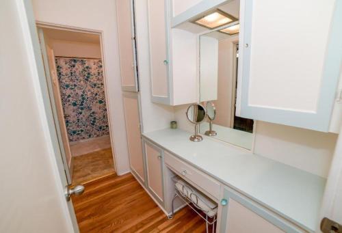 a bathroom with a counter with a mirror and a sink at BEACHFRONT COTTAGE UPPER UNIT in Oceanside