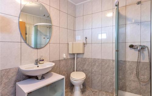 ein Badezimmer mit einem WC, einem Waschbecken und einem Spiegel in der Unterkunft 1 Bedroom Gorgeous Apartment In Fazana in Fažana