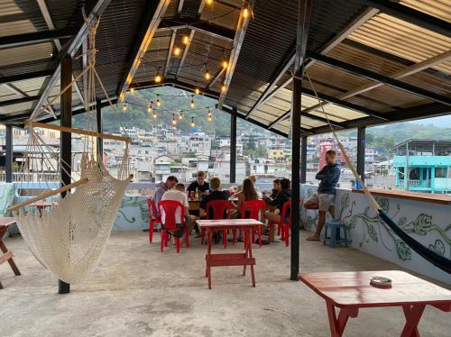 um restaurante com pessoas sentadas em mesas e uma rede de descanso em Hostal Corazón de San Pedro em San Pedro La Laguna