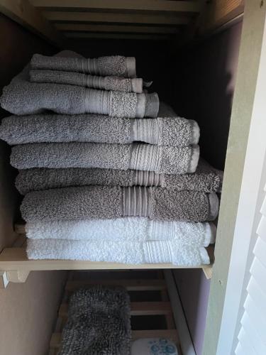 a bunch of towels are stacked on a shelf at The Welcome Apartment in Blackpool