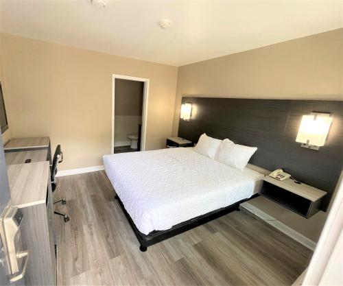 a hotel room with a bed and a telephone at Shangri-La Motel in Seekonk