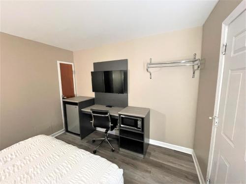 a bedroom with a desk with a computer and a bed at Shangri-La Motel in Seekonk