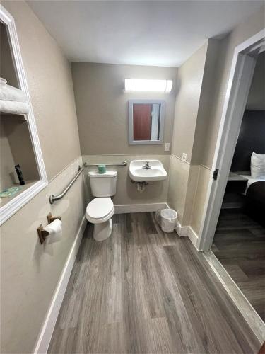 La petite salle de bains est pourvue de toilettes et d'un lavabo. dans l'établissement Shangri-La Motel, à Seekonk