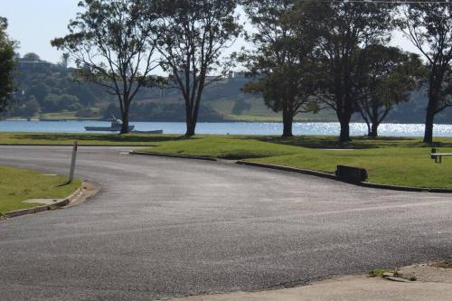 an empty road next to a body of water at Old fisherman's house on barkes - pet and family friendly in Lakes Entrance