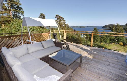 a white couch on a wooden deck with a table at Amazing Home In Uddevalla With Kitchen in Uddevalla