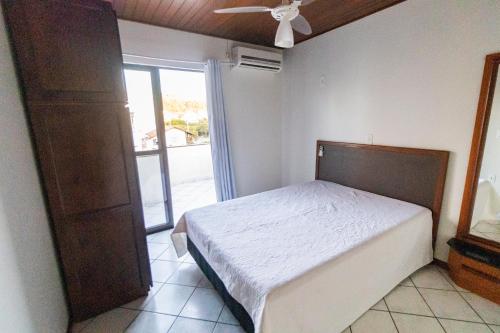 1 dormitorio con 1 cama y puerta corredera de cristal en Apartamento Cobertura - 140 metros da praia, en Bombinhas