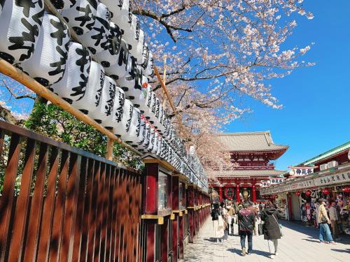 a group of people walking down a street next to a building at HOTEL TAVINOS ASAKUSA - Vacation STAY 64889 in Tokyo