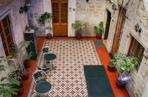 an outdoor patio with tables and chairs and plants at Hotel La Posada de Ugarte in Arequipa