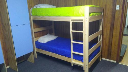 a couple of bunk beds with a blue bed at Islanet Hostel & Bar in Puerto Montt