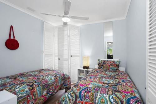 a bedroom with two beds and a ceiling fan at Cosy Corner - BYO Linen in Torquay