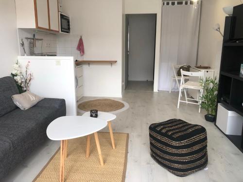 salon z kanapą i stołem w obiekcie Charmant 2 pièces proche de la plage de Socoa w mieście Urrugne