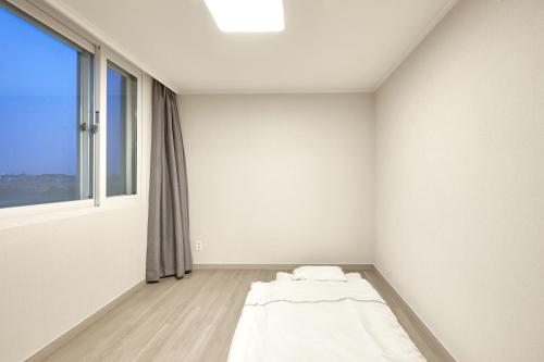 Habitación blanca con cama y ventana en Kumho Seorak Resort, en Sokcho