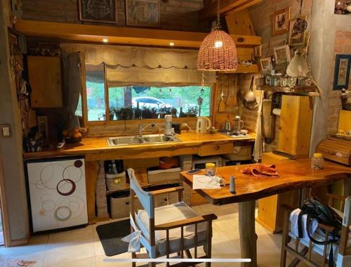 una cocina con una gran mesa de madera y un fregadero en CASA CAMPO en Villa General Belgrano
