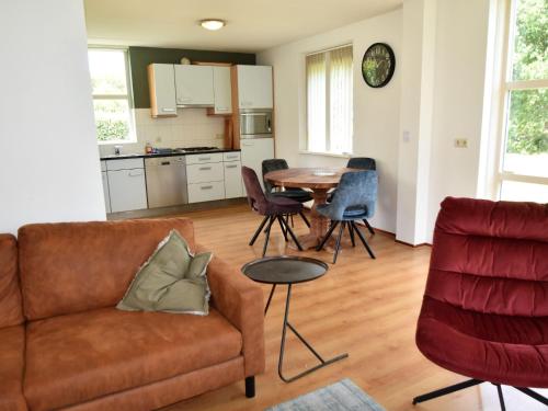 a living room with a couch and a table at Holiday Home in Flevoland with Pool in Zeewolde