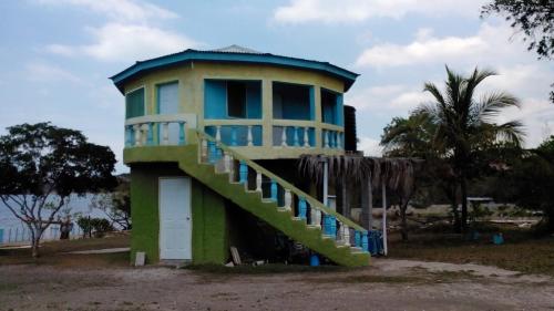 a house with a staircase in front of it at Waikiki Guest House in Treasure Beach