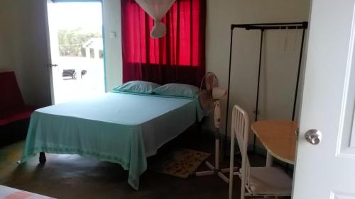 a bedroom with a bed with a red window at Waikiki Guest House in Treasure Beach