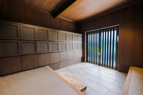 a room with wooden walls and a large window at SKI INN HAKUBA in Otari