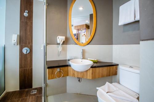 W łazience znajduje się umywalka i lustro. w obiekcie Tjokro Style Yogyakarta w mieście Yogyakarta
