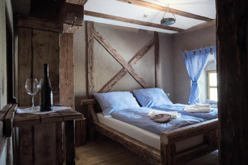 a bedroom with a bed with blue sheets and a window at Krčma Hotel U Císařské Cesty in Branišovice