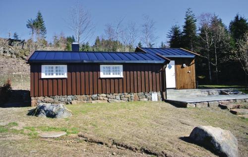 une petite maison avec un toit bleu sur un champ dans l'établissement Gorgeous Home In Farsund With Kitchen, à Farsund