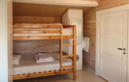 um quarto com beliches num chalé de madeira em Gorgeous Home In Farsund With Kitchen em Farsund