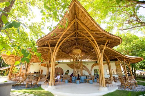 セロング・ベラナクにあるTropik Resort Lombokの大きな木造パビリオン(テーブル、椅子付)