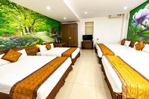 three beds in a room with a painting on the wall at Hoa Viên Hotel - Suối khoáng Kim Bôi in Hòa Bình