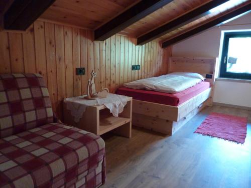 a room with two beds and a chair in it at Ciasa Gabriel in Colfosco