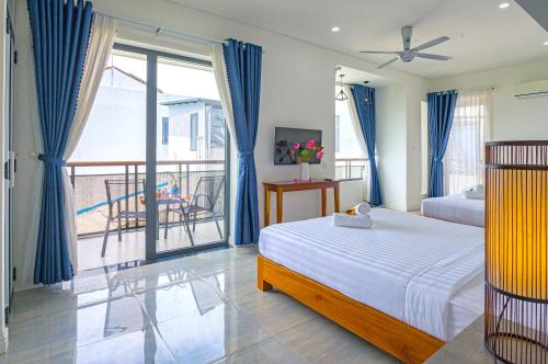 a bedroom with a bed and a balcony at Aroma Garden Suites Hoi An in Hoi An