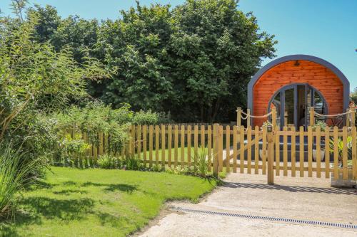 a wooden fence with a gate in a garden at Filbert Pod in Arundel
