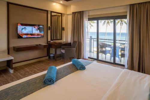 a hotel room with a bed with a view of the ocean at Parklane Bohol Resort and Spa in Anda