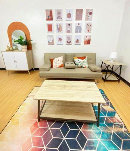 a living room with a couch and a coffee table at Nordic Themed 1BR Condo - 50 mbps net - Marilao Bulacan - TheRichPlacePh in Marilao