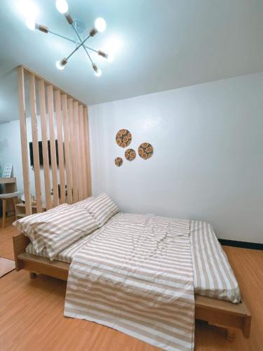 a bedroom with a bed and a clock on the wall at Nordic Themed 1BR Condo - 50 mbps net - Marilao Bulacan - TheRichPlacePh in Marilao