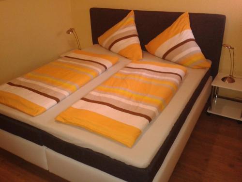 2 Betten mit gestreiften Decken und Kissen darauf in der Unterkunft Ferienwohnung Weiss in Rust