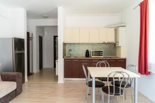 uma cozinha e sala de estar com mesa e cadeiras em Apartament Tudor em Mamaia Nord – Năvodari