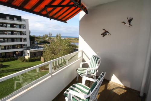 two chairs on a balcony with birds on the wall at Steinwarder 1 - Haus "Seerose" ST1 034 Steinwarder 1 in Heiligenhafen
