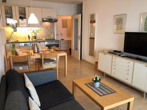 a living room and kitchen with a couch and a table at Steinwarder 1 - Haus "Seerose" ST1 055 Steinwarder 1 in Heiligenhafen