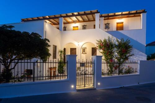 a white house with a gate at night at Villa Kriezi in Spetses