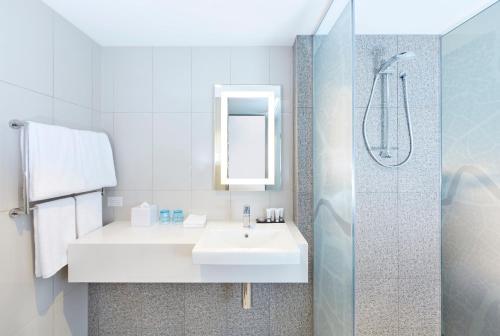 a white bathroom with a sink and a shower at Holiday Inn Express Brisbane Central by IHG in Brisbane