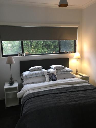 a bedroom with a large bed with a large window at a'meadow in Trentham