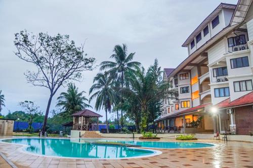un hotel con piscina di fronte a un edificio di ēRYA by SURIA Cherating a Cherating