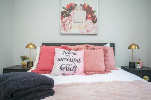a bedroom with a bed with pink pillows at "WATERLILY HOUSE" - Luxury Canal House, Jetty, Dog & Child Friendly - Sleeps 14 in Mandurah