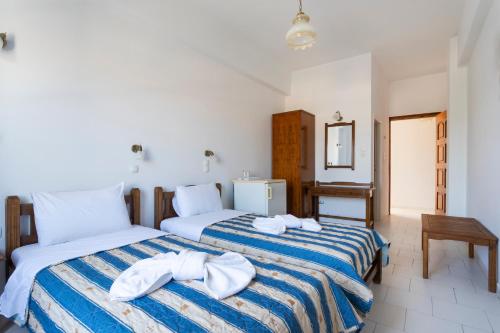 a bedroom with two beds with towels on them at Villa Kriezi in Spetses