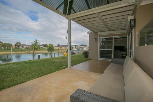 a porch of a house with a view of a river at "WATERLILY HOUSE" - Luxury Canal House, Jetty, Dog & Child Friendly - Sleeps 14 in Mandurah