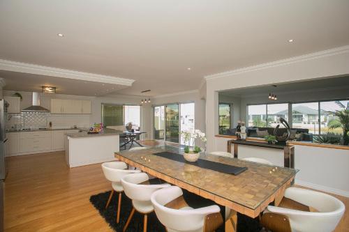 a large kitchen with a wooden table and chairs at "WATERLILY HOUSE" - Luxury Canal House, Jetty, Dog & Child Friendly - Sleeps 14 in Mandurah