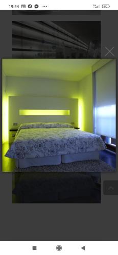 1 dormitorio con 1 cama blanca con luz verde en Casa Marisa, en San Asensio