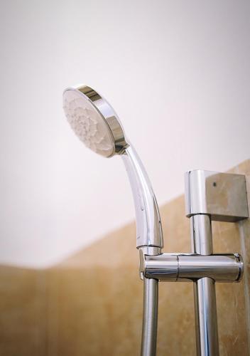 a shower head in a bathroom next to a wall at Salt Resort & Spa in Amed