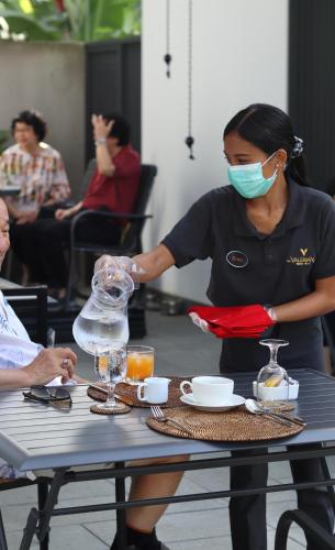 a woman wearing a face mask standing at a table at The Valerian Villa Ubud in Ubud