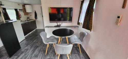 a room with a table and chairs and a television at Świętokrzyska Italia in Włochy